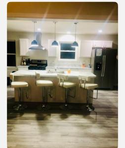 a kitchen with a counter with stools in it at Warmth Private Room in Stillwater Lake Estates