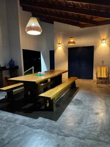a dining room with a wooden table and a bench at Casa Woody in Santo Amaro