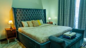 a bedroom with a large bed with a blue headboard at Serene Abodes MB7 in Kampala
