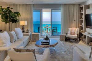 a living room with white furniture and a view of the ocean at Ultra Luxe Direct Ocean Penthouse at 1 Hotel in Miami Beach