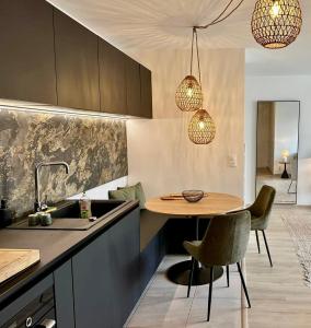 a kitchen with a sink and a table and chairs at Charmant appartement T3 contemporain au bord de l'eau sur le Bassin Arcachon in Lanton