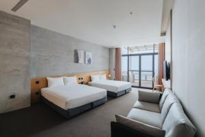 a hotel room with two beds and a couch at 緩慢大鵬灣 in Donggang