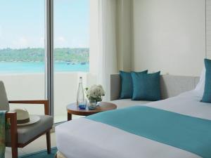 a hotel room with a bed and a view of the water at ANA InterContinental Manza Beach Resort by IHG in Onna
