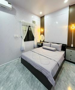 a bedroom with a large bed and a window at Ngôi Nhà Hạnh Phúc in Plei Kêp