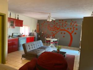 ein Wohnzimmer mit einer Couch und einem Baumwandbild in der Unterkunft loft rosy in Puerto Peñasco