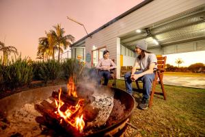 two people sitting in chairs around a fire pit at BIG4 Big River Holiday Park in Seelands