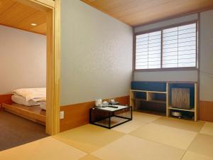 a bedroom with a bed and a table and a window at Zao Sunvalley Hotel in Yamagata
