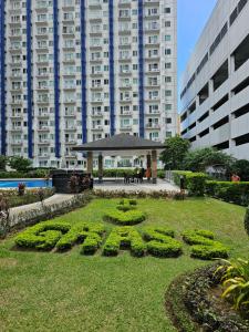 a park in front of a building with a sign in the grass at Stay at Love Grass in Manila