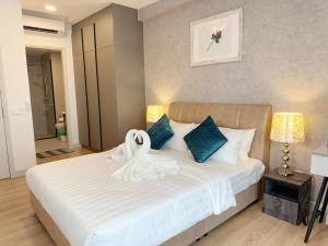 a bedroom with a bed with a swan on it at The Atrium at Jalan Ampang by OKBnB - Luxury 3 Bedroom Family Suite with Balcony, 3 mins to KLCC in Kuala Lumpur +27 photos
