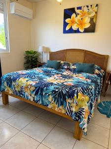 a bedroom with a bed with a blue and yellow blanket at Heiata Lodge Papeete in Papeete