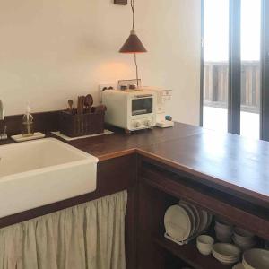 a kitchen counter with a microwave and a sink at Deokin Mansion in Jeju +26 photos