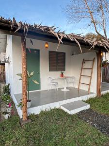 a house with a patio with a table and chairs at Garden Village in El Nido