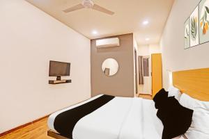 ラクナウにあるSuper Townhouse Mukut Bazarのベッドと壁にテレビが掛かった寝室 +25枚の写真