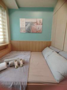 two beds in a small room with towels on them at Stay at Love Grass in Manila