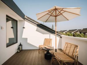 eine Terrasse mit zwei Stühlen, einem Tisch und einem Sonnenschirm in der Unterkunft Shine on in Kunshan