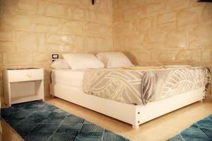 ein weißes Bett in einem Zimmer mit Ziegelwand in der Unterkunft Nubian Hights guesthouse in Shellal + 10 Fotos