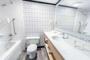 a bathroom with a sink and a toilet and a tub at Sternwheeler Hotel & Conference Centre, Trademark by Wyndham in Whitehorse