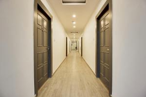 an empty corridor with two doors and a long hallway at Super Townhouse 359 Begumpet Near Hyderabad Central in Hyderabad +53 photos