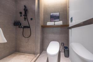 a bathroom with a shower and a toilet and a sink at Atour Hotel Hefei Huaihe Road Pedestrian Street City Hall Square in Hefei