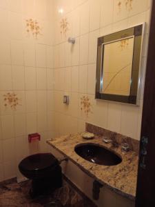 a bathroom with a sink and a toilet at Casa Praia Jardim Acapulco in Guarujá +15 photos