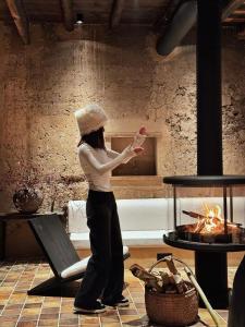 Eine Frau steht vor einem Feuer in der Unterkunft Jiuli Countryside Boutique resort in Xinchang + 146 Fotos