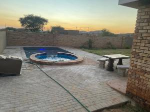 a patio with a pool and a bench and a table at SapzRes at Taung in Lethola