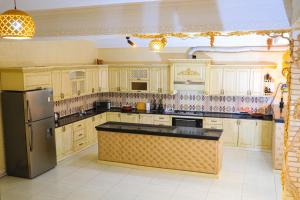 Una cocina con gabinetes de madera y un refrigerador negro. en ELANI Hotel, en Samarkand