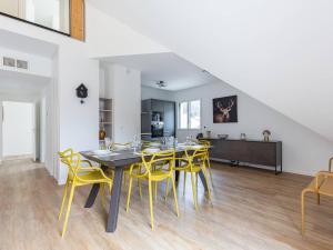 une salle à manger avec une table et des chaises jaunes dans l'établissement Grand Appartement Moderne, Proche Pistes, 8 Pers., Parking Inclus - FR-1-296-514, à Saint-Lary-Soulan