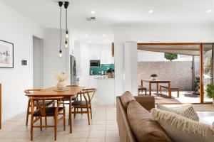 una sala de estar con un sofá y una mesa en Chalfont Way @ Glengowrie - WiFi BBQ Family, en Somerton Park