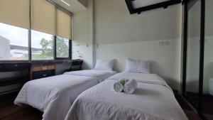 DukuにあるGuest House 555 NKIのベッド2台(タオル付)が備わる客室です。