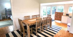 een eetkamer met een houten tafel en stoelen bij Springs Beach House in Point Lonsdale +4 foto's