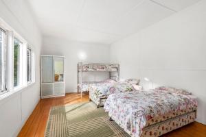 een slaapkamer met twee bedden en een spiegel bij Springs Beach House in Point Lonsdale
