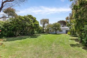 een lege tuin voor een huis bij Springs Beach House in Point Lonsdale