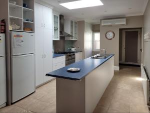 a kitchen with white appliances and a blue counter top at The Manse in Queenscliff +7 photos
