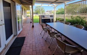 a patio with a table and chairs and a grill at The Manse in Queenscliff