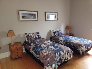 a bedroom with two beds and two lamps on the wall at The Manse in Queenscliff