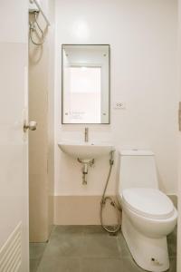 a bathroom with a toilet and a sink at Tranquility in the City in Iloilo City