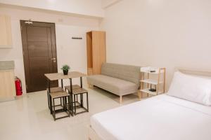 a bedroom with a bed and a couch and a table at Urban Nest with a View in Iloilo City +2 photos