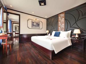 um quarto com uma grande cama branca e uma secretária em Le Journey Elegance Cruise em Ha Long