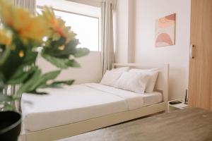 a bedroom with a bed and a vase of flowers at A Simple Cozy Retreat in Iloilo City