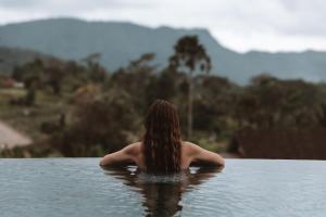 una donna seduta in una piscina d'acqua di Samanvaya - Adults Only a Sidemen Altre 59 foto