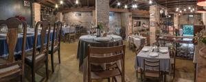 a dining room with tables and chairs and brick walls at Hospedaria Os Memorialistas - Paranapiacaba in Paranapiacaba