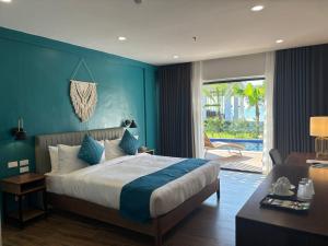 a bedroom with a bed with a blue wall at Hudor Resort - Bauang, La Union in Lossoc