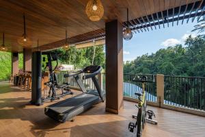 an outdoor fitness room with exercise equipment on the balcony at Metland Venya Ubud in Ubud