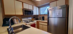 a kitchen with a stainless steel refrigerator and a sink at Woods Village 43 in Killington +30 photos
