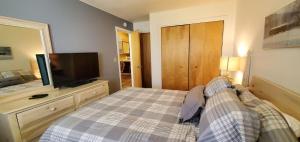 a bedroom with a bed and a flat screen tv at Woods Village 43 in Killington