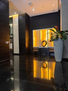 a lobby with a vase with flowers on the floor at The Air Residences #3724 in Manila +75 photos