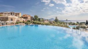 a large pool of blue water with buildings in the background at Appartement LES PETITS PRINCES in Agay - Saint Raphael