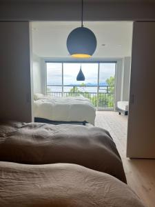 una camera da letto con due letti e vista sull'oceano di 真鶴ペットと泊まれて専用屋上付きスタイリッシュなapartmentHotel途乃中RC2 a Manazuru