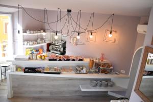 a coffee shop with lights and food on shelves at Hotel Fiori in Rome